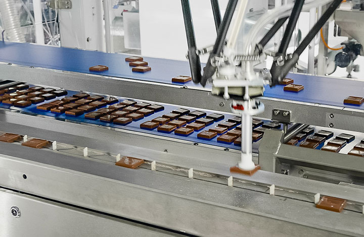At this station, the chocolates are removed from the mold and then wrapped At this station, the chocolates are removed from the mold and then wrapped