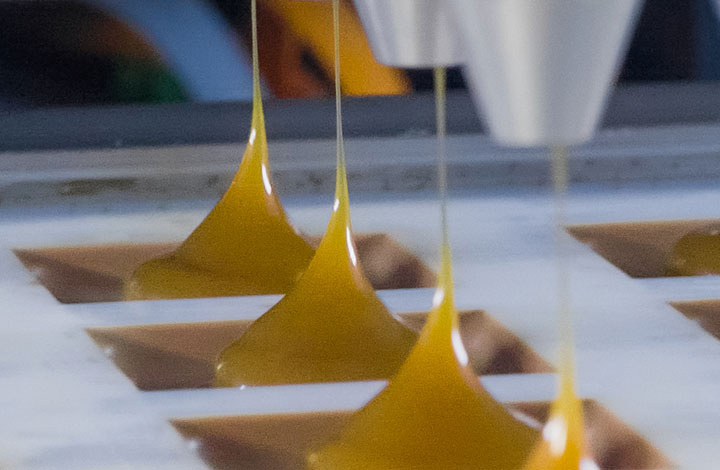 The chocolate shells are filled at the filling station The chocolate shells are filled at the filling station
